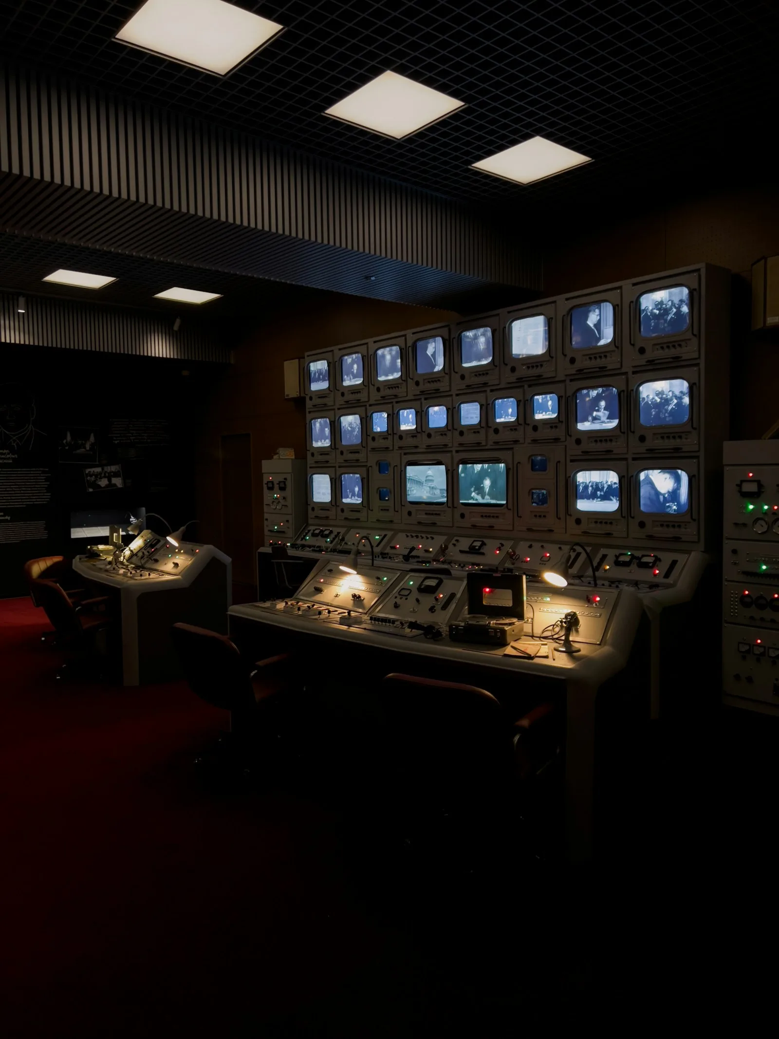 A control room with a wall of monitoring screens